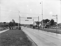 167260 Gezicht op een met handmatig bediende overwegbomen beveiligde spoorwegovergang te Ede.